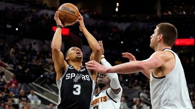 San Antonio Spurs forward Keldon Johnson (3) drives to the basket against Denver Nuggets guard Reggie Jackson (7) and center Nikola Jokic (15) during the first half at AT&T Center. (USA TODAY Sports)
