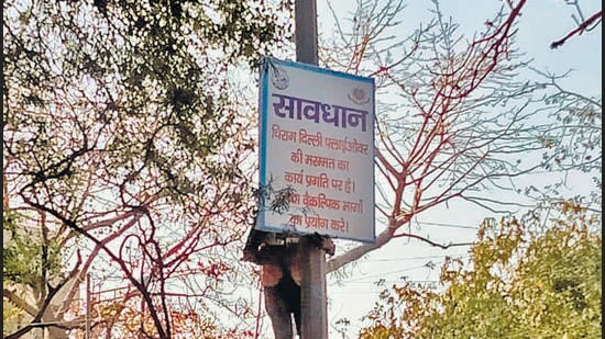 A hoarding alerts commuters that repair work on the Chirag Delhi flyover is underway. In an advisory issued on Thursday, Delhi Traffic Police had announced that one carriageway on the flyover will be shut from Sunday. (HT Photo)