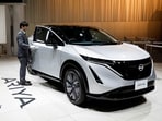 An employee opens the door of a Nissan Ariya EV car at Nissan Gallery in Yokohama, Japan.