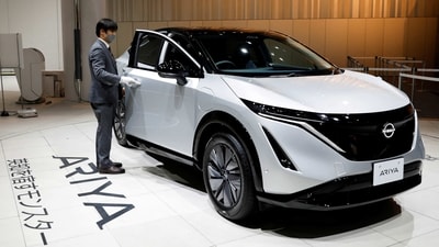 An employee opens the door of a Nissan Ariya EV car at Nissan Gallery in Yokohama, Japan. (REUTERS)