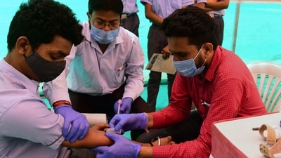 A health worker (R) collects blood sample from a school student for health checkup as a precaution against the H3N2 virus. (AFP) A health worker (R) collects blood sample from a school student for health checkup as a precaution against the H3N2 virus. (AFP)