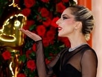 Lady Gaga gestures on the champagne-colored red carpet during the Oscars arrivals at the 95th Academy Awards in Hollywood, Los Angeles, California, US. Here's here look in a  butt-baring see-through corset gown at the red carpet to no-makeup performance look 