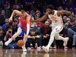 Washington Wizards center Kristaps Porzingis (6) and Philadelphia 76ers center Joel Embiid (21) chase after loose ball during the first quarter at Wells Fargo Center.