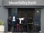 People look at signs posted outside of an entrance to Silicon Valley Bank in Santa Clara. People look at signs posted outside of an entrance to Silicon Valley Bank in Santa Clara.