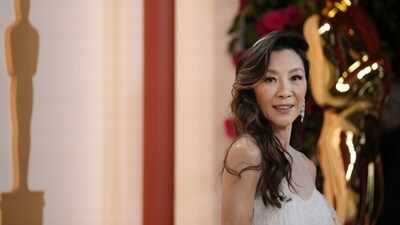 Academy Award Best Actor nominee Michelle Yeoh attended the Oscars ceremony in a Dior gown. She wore an ivory ensemble featuring a sheer neckline, tassel embellishments, a floor-sweeping train, a statement ring, a hair ornament, dangling diamond earrings, a sleek watch, and side-parted wavy tresses. (Ashley Landis/Invision/AP) Academy Award Best Actor nominee Michelle Yeoh attended the Oscars ceremony in a Dior gown. She wore an ivory ensemble featuring a sheer neckline, tassel embellishments, a floor-sweeping train, a statement ring, a hair ornament, dangling diamond earrings, a sleek watch, and side-parted wavy tresses. (Ashley Landis/Invision/AP)