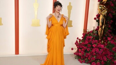 Sandra Oh looks fierce in an orange Giambattista Valli Haute Couture gown glammed with jewels from Briony Raymond, a messy hairdo, and bold red lips. (Jordan Strauss/Invision/AP) Sandra Oh looks fierce in an orange Giambattista Valli Haute Couture gown glammed with jewels from Briony Raymond, a messy hairdo, and bold red lips. (Jordan Strauss/Invision/AP)