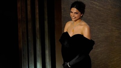 Deepika Padukone introduces the song Naatu Naatu from RRR at the Oscars on Sunday. For the event, Deepika wore a black dress and a silver-yellow neckpiece. (AP) Deepika Padukone introduces the song Naatu Naatu from RRR at the Oscars on Sunday. For the event, Deepika wore a black dress and a silver-yellow neckpiece. (AP)