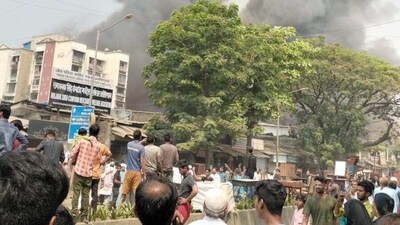 People from nearby areas watch as smoke erupts from from the fire spot. The cause of the fire is yet to be ascertained. (Aahraf Adenwala/ HT)