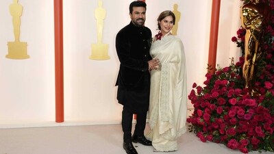 Ram Charan and his wife Upasana arrive at the Oscars on Sunday. The couple opted for ethnic outfits--Ram wore a black ensemble while Upasana draped a cream saree. (AP) Ram Charan and his wife Upasana arrive at the Oscars on Sunday. The couple opted for ethnic outfits--Ram wore a black ensemble while Upasana draped a cream saree. (AP)