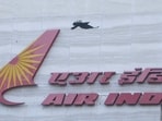 A bird flies over a logo of Air India airlines at the corporate headquarters in Mumbai, India.