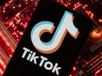 A smartphone with a displayed TikTok logo is placed on a computer motherboard in this illustration.