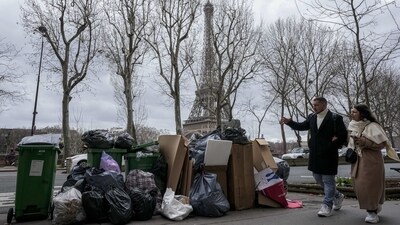 People walk past uncollected garbage cans near the Eiffel Tower in Paris, on March 12. The City of Light is losing its luster with tons of garbage piling up on Paris sidewalks as sanitation workers continued their strike for the ninth day, on Tuesday, reported AP. (Michel Euler / AP) People walk past uncollected garbage cans near the Eiffel Tower in Paris, on March 12. The City of Light is losing its luster with tons of garbage piling up on Paris sidewalks as sanitation workers continued their strike for the ninth day, on Tuesday, reported AP. (Michel Euler / AP)