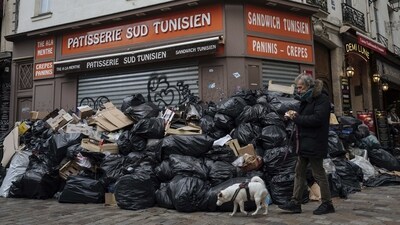 A man walks his dog past piles of garbage in Paris, on March 13. (Lewis Joly / AP) A man walks his dog past piles of garbage in Paris, on March 13. (Lewis Joly / AP)