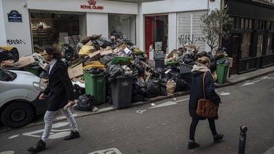 People walk past uncollected garbage in Paris, on March 13. Gursel Durnaz, who has been on a picket line for nine days, told AP, “There are bins everywhere, stuff all over. People can’t get past. We’re completely aware.” But, he added, President Emmanuel Macron has only to withdraw his plan to increase the French retirement age “and Paris will be clean in three days.” (Lewis Joly / AP) People walk past uncollected garbage in Paris, on March 13. Gursel Durnaz, who has been on a picket line for nine days, told AP, “There are bins everywhere, stuff all over. People can’t get past. We’re completely aware.” But, he added, President Emmanuel Macron has only to withdraw his plan to increase the French retirement age “and Paris will be clean in three days.” (Lewis Joly / AP)