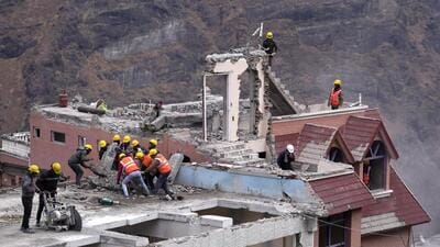 Labourers demolish a building in Joshimath. (AP)