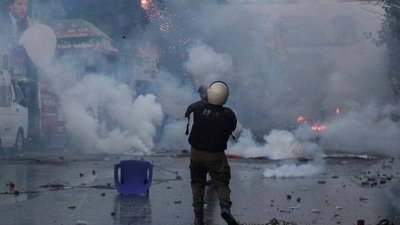 Imran Khan News: A police officer fires a tear gas shell to disperse the supporters of former Pakistani Prime Minister Imran Khan. (Reuters)