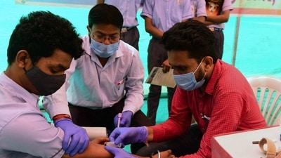 A health worker (R) collects blood sample from a school student for health checkup as a precaution against the H3N2 virus. (AFP) A health worker (R) collects blood sample from a school student for health checkup as a precaution against the H3N2 virus. (AFP)