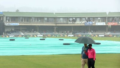 Umpire Bongani Jele holds an umbrella after inspecting the pitch before the match is called off due to rain (REUTERS)