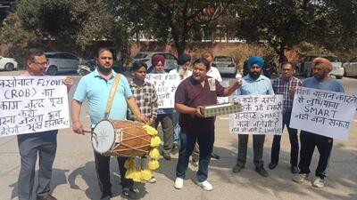Residents and NGO members staging a protest highlighting the lack of street lights on the Malhar road in Ludhiana. (HT File)