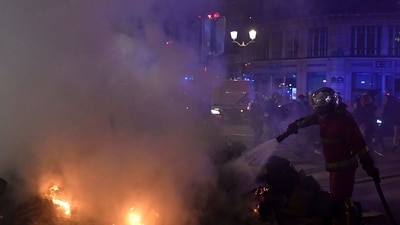 France Protests: A French firefighter puts out a fire lit by protesters during a demonstration after the French government pushed a pensions reform through parliament without a vote. (AFP) France Protests: A French firefighter puts out a fire lit by protesters during a demonstration after the French government pushed a pensions reform through parliament without a vote. (AFP)