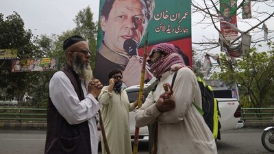 Imran Khan News: Supporters of former Prime Minister Imran Khan gather with sticks near the Khan's residence, in Lahore. (AP) Imran Khan News: Supporters of former Prime Minister Imran Khan gather with sticks near the Khan's residence, in Lahore. (AP)