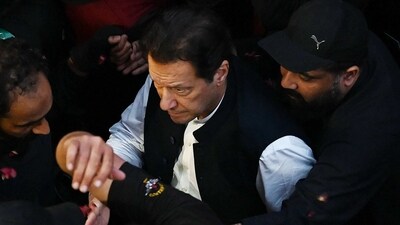 Security personnel escort former Pakistan's Prime Minister Imran Khan as he arrives to appear at the high court in Lahore on Friday. (AFP) Security personnel escort former Pakistan's Prime Minister Imran Khan as he arrives to appear at the high court in Lahore on Friday. (AFP)