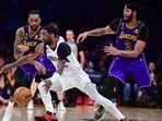 Dallas Mavericks guard Kyrie Irving (2) moves the ball against Los Angeles Lakers guard D'Angelo Russell (1) and forward Anthony Davis (3) during the second half at Crypto.com Arena. 