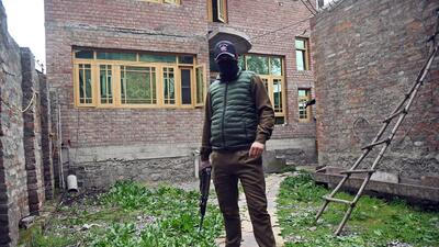 A cop stands guard as state investigation agency conducts raid in Jammu and Kashmir on Saturday. (ANI Photo) A cop stands guard as state investigation agency conducts raid in Jammu and Kashmir on Saturday. (ANI Photo)