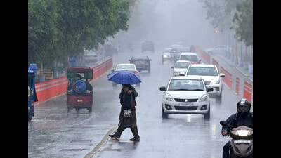 Commuters out in the rain in Chandigarh on Saturday. (Ravi Kumar/ HT)