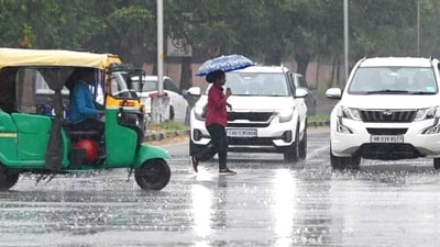 A woman with an umbrella crossing a busy road as rain lashed Chandigarh. (Ravi Kumar/ HT) A woman with an umbrella crossing a busy road as rain lashed Chandigarh. (Ravi Kumar/ HT)