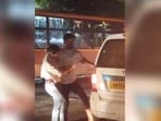 A screenshot of the video in which a man can be seen beating a woman and forcing her to get inside a cab.. A screenshot of the video in which a man can be seen beating a woman and forcing her to get inside a cab..