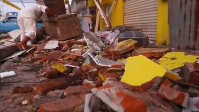 A resident recovers belongings amid the debris of a collapsed home after an earthquake shook Machala, Ecuador on Saturday, March 18. (AP) A resident recovers belongings amid the debris of a collapsed home after an earthquake shook Machala, Ecuador on Saturday, March 18. (AP)