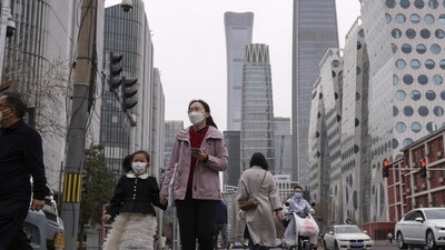 China Flu Outbreak: Pedestrian and motorists cross a traffic intersection near the Central Business District in Beijing. (AP)