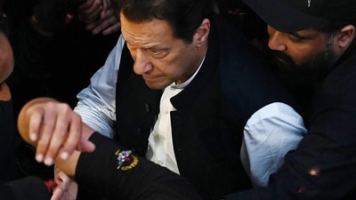 Security personnel escort former Pakistan's Prime Minister Imran Khan as he arrives to appear at the high court in Lahore on Friday. (AFP) Security personnel escort former Pakistan's Prime Minister Imran Khan as he arrives to appear at the high court in Lahore on Friday. (AFP)