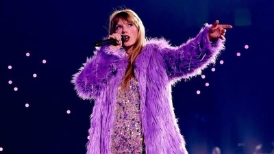 Taylor Swift in purple shaggy coat and sequined dress. 
