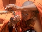 Fadumo Isaq Abdi, an internally displaced Somali woman, holds her child Maria Mohamed Ali as they drink water outside the feeding centre, a new site for IDPs, in Barwaaqo, near Baidoa, Somalia.