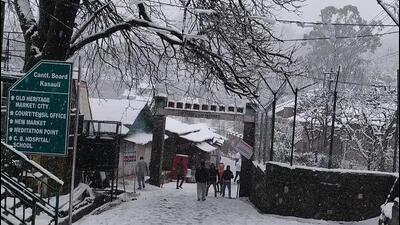 People take a stroll on a hailstone-laden road in Kasauli of Solan district on Monday. (HT Photo)