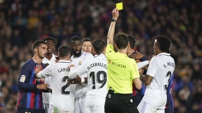 Referee Ricardo de Burgos Bengoetxea shows a yellow card as p[layers react during the Spanish La Liga match between Barcelona and Real Madrid at Camp Nou (AP) Referee Ricardo de Burgos Bengoetxea shows a yellow card as p[layers react during the Spanish La Liga match between Barcelona and Real Madrid at Camp Nou (AP)