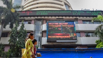 Market updates today: People walk past an electronic signage displayed at the Bombay Stock Exchange (BSE) building. (PTI)