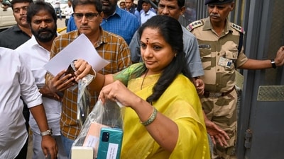 BRS MLC K Kavitha waving mobile phones outside the ED office. (PTI) BRS MLC K Kavitha waving mobile phones outside the ED office. (PTI)