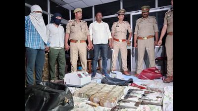 The arrested accused with seized firearms and cash in police custody. (HT photo) The arrested accused with seized firearms and cash in police custody. (HT photo)