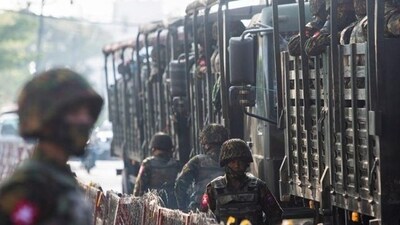 Myanmar: A soldier stand next to military vehicles as people gather to protest against a military coup in Yangon, Myanmar. Myanmar: A soldier stand next to military vehicles as people gather to protest against a military coup in Yangon, Myanmar.