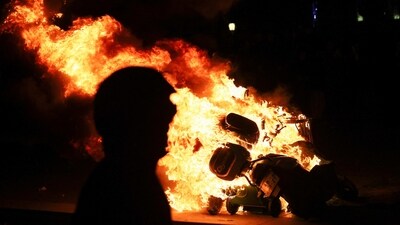 A person stands near a burning scooter, as protesters gather at Place de la Republique during a demonstration, in Paris, March 21. “When there were 3.5 million of us in the streets, well, Emmanuel Macron still did not listen to what we had to tell him…So now we have to shift to more radical means of action, especially blocking the economy,” student Elonore Shmitt told Reuters. (Yves Herman / REUTERS) A person stands near a burning scooter, as protesters gather at Place de la Republique during a demonstration, in Paris, March 21. “When there were 3.5 million of us in the streets, well, Emmanuel Macron still did not listen to what we had to tell him…So now we have to shift to more radical means of action, especially blocking the economy,” student Elonore Shmitt told Reuters. (Yves Herman / REUTERS)