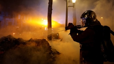 In a photo from March 21, a firefighter extinguishes a fire during a demonstration, after the pension reform was adopted in Paris. Unions have called for new nationwide protests on March 24, to demand the government simply withdraw the retirement bill, AP reported. (Gonzalo Fuentes / REUTERS) In a photo from March 21, a firefighter extinguishes a fire during a demonstration, after the pension reform was adopted in Paris. Unions have called for new nationwide protests on March 24, to demand the government simply withdraw the retirement bill, AP reported. (Gonzalo Fuentes / REUTERS)