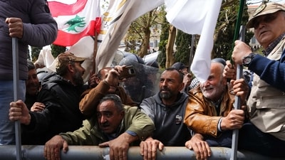 Retired members of the Lebanese security and other protesters try to remove a gate in order to advance towards the government building, background, during a protest demanding better pay in Beirut, Lebanon, Wednesday. (AP) Retired members of the Lebanese security and other protesters try to remove a gate in order to advance towards the government building, background, during a protest demanding better pay in Beirut, Lebanon, Wednesday. (AP)