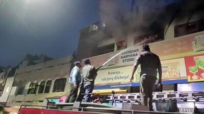 Fire brigade officials dousing the flames during a fire at the grocery store’s godown in Samrala. (HT Photo)