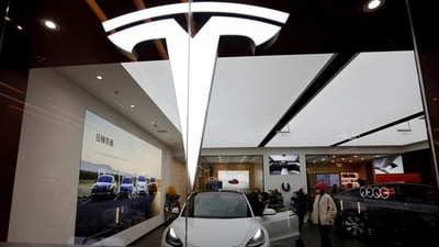 Visitors check a Tesla Model 3 car next to a Model Y displayed at a showroom of the U.S. electric vehicle (EV) maker in Beijing, China. (REUTERS)