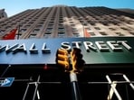 A sign for a Wall Street building is shown, 