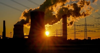 Steam rises from the coal-fired power plant near wind turbines Niederaussem, Germany, as the sun rises on Wednesday, Nov. 2, 2022. Germany cut its greenhouse gas emissions by almost 2% last year, beating previous estimates but still falling far short of the cuts needed to meet its medium-term climate goals. (AP Photo)