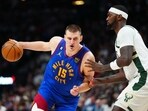  Denver Nuggets center Nikola Jokic (15) drives at Milwaukee Bucks forward Bobby Portis (9) during the second half at Ball Arena. 